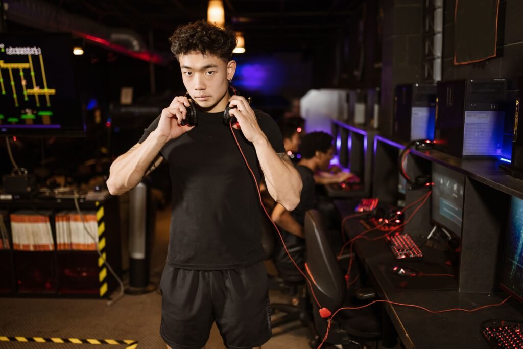 A serious young man in a gaming lounge with headphones, embodying the modern e-sports culture.